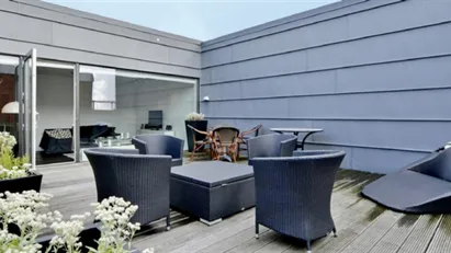 Nyrenoveret penthouse med stor tagterrasse .